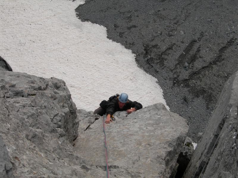 Steven dans la dernière longueur au dessus de la terrasse d'éboulis qui coupe la face