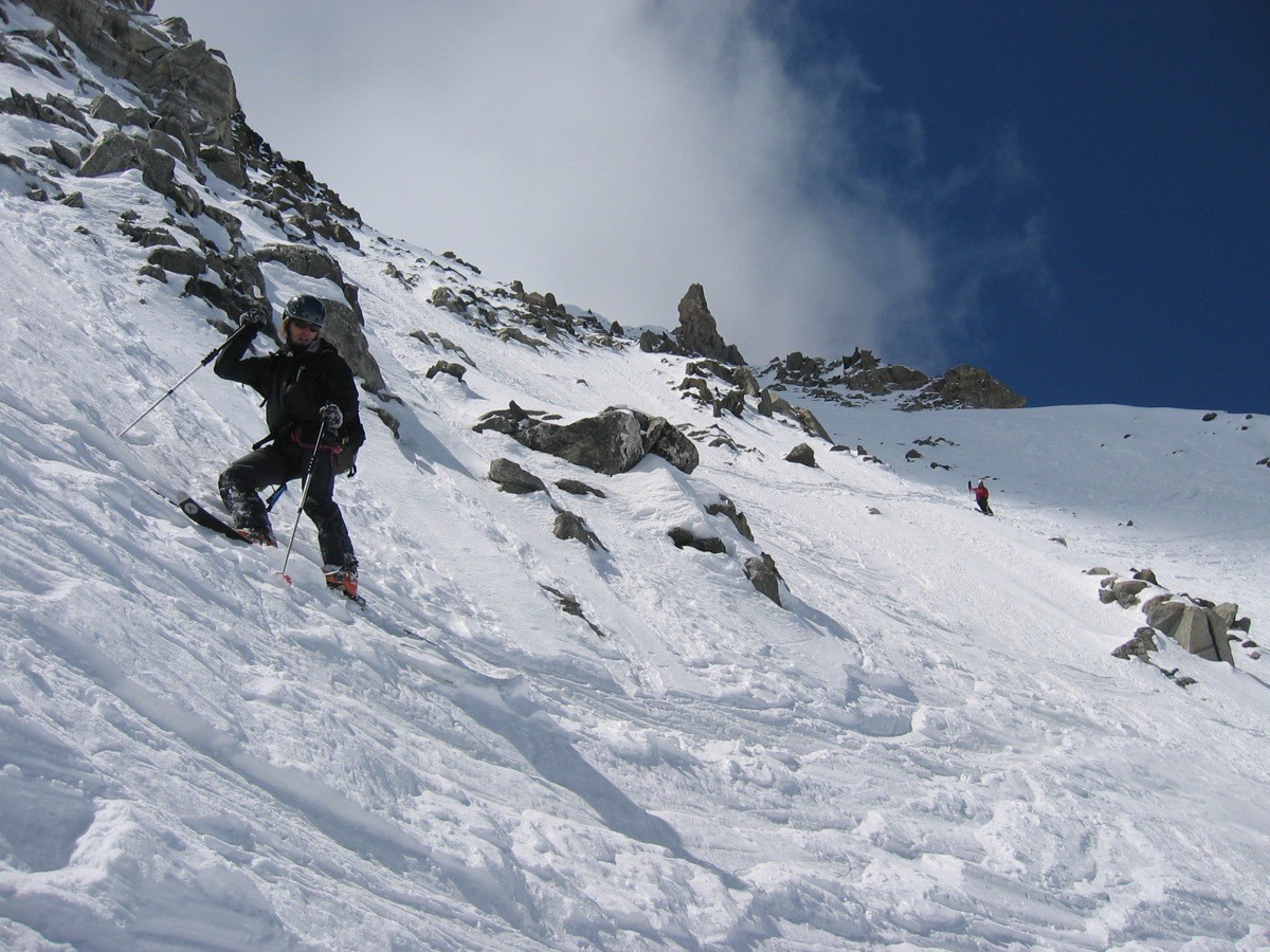 Des rochers émergent dans le haut de la pente NE du col des Cristaux