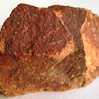 Rhyolite. La rhyolite est une roche microgrenue d'origine volcanique. La teinte rouge est ici due à des phénomènes oxydatifs.