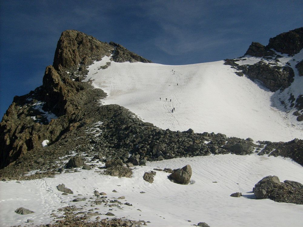 image classique, on aperçoit le petit couloir de neige à traverser à gauche dans la partie rocheuse terminale