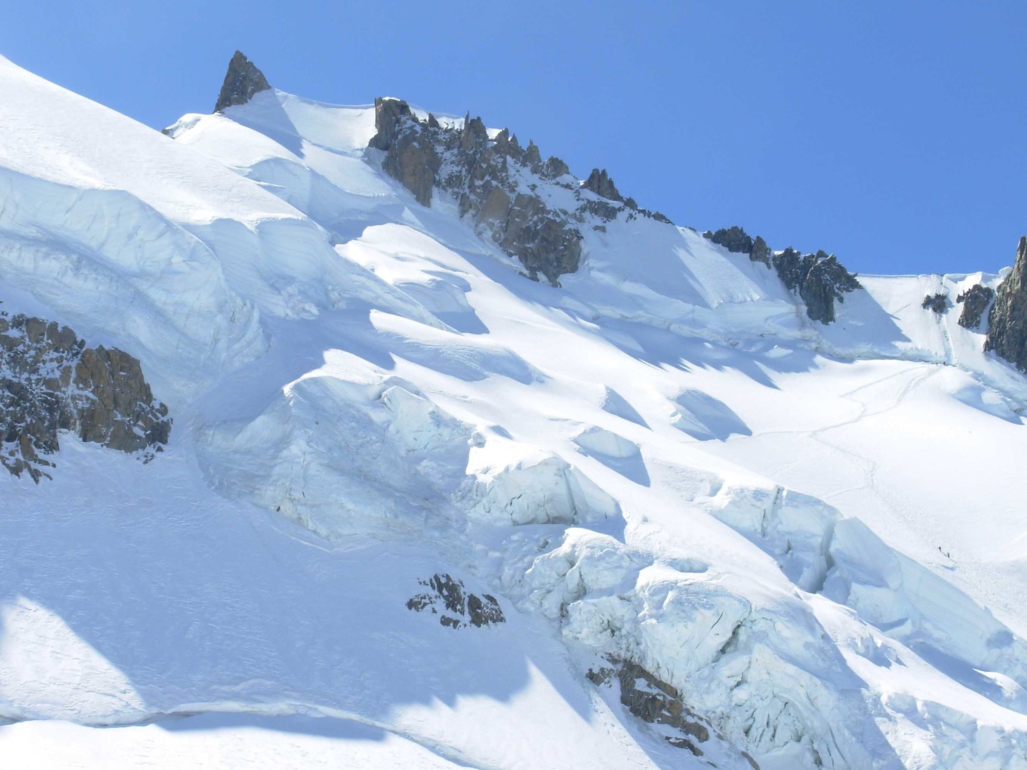 Vue d'ensemble de droite à gauche : pente raide après rimaye épaule Maudit, arête NW, arête neigeuse présommitale, éperon rocheux du Maudit