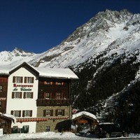 L'Hôtel du Glacier d'Arolla devant la Pointe des Genevois, la Dent de Perroc et la Petite Veisivi.
