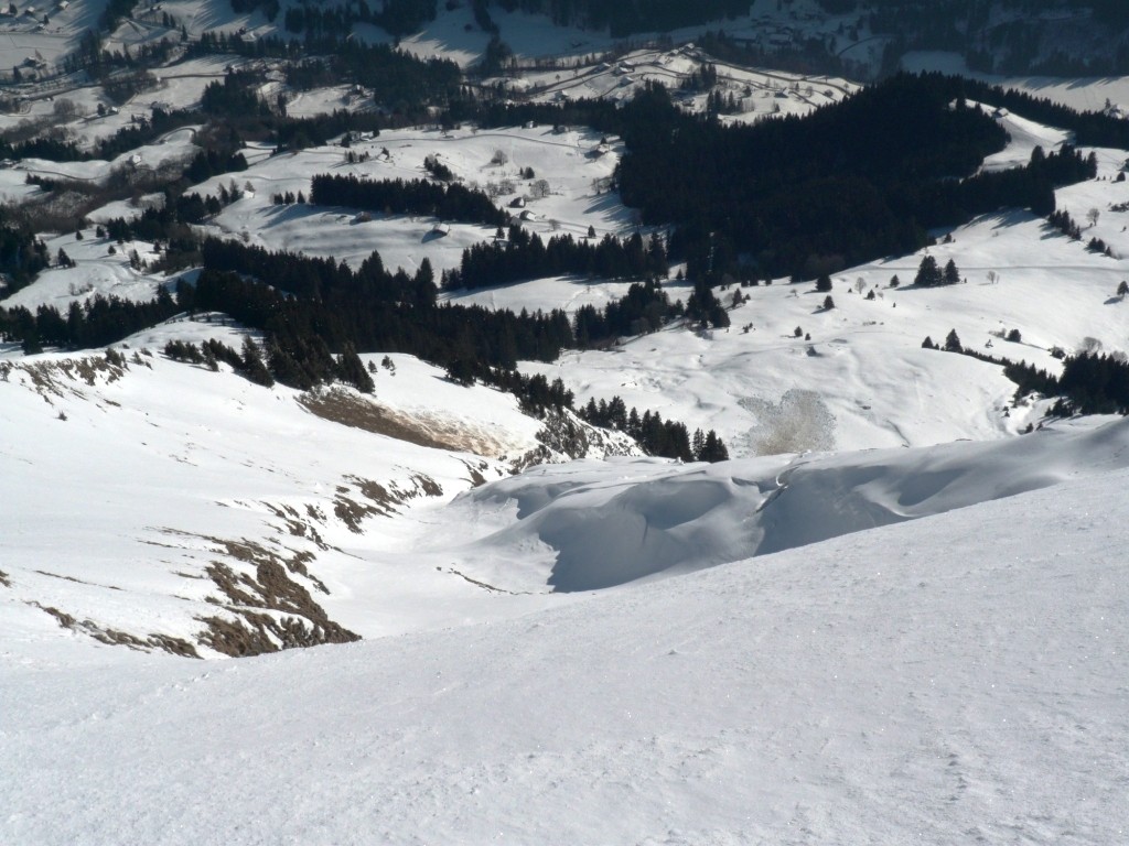 Vue sur le grand couloir S du sommet. La plaque partie sur l'herbe est visible rive gauche