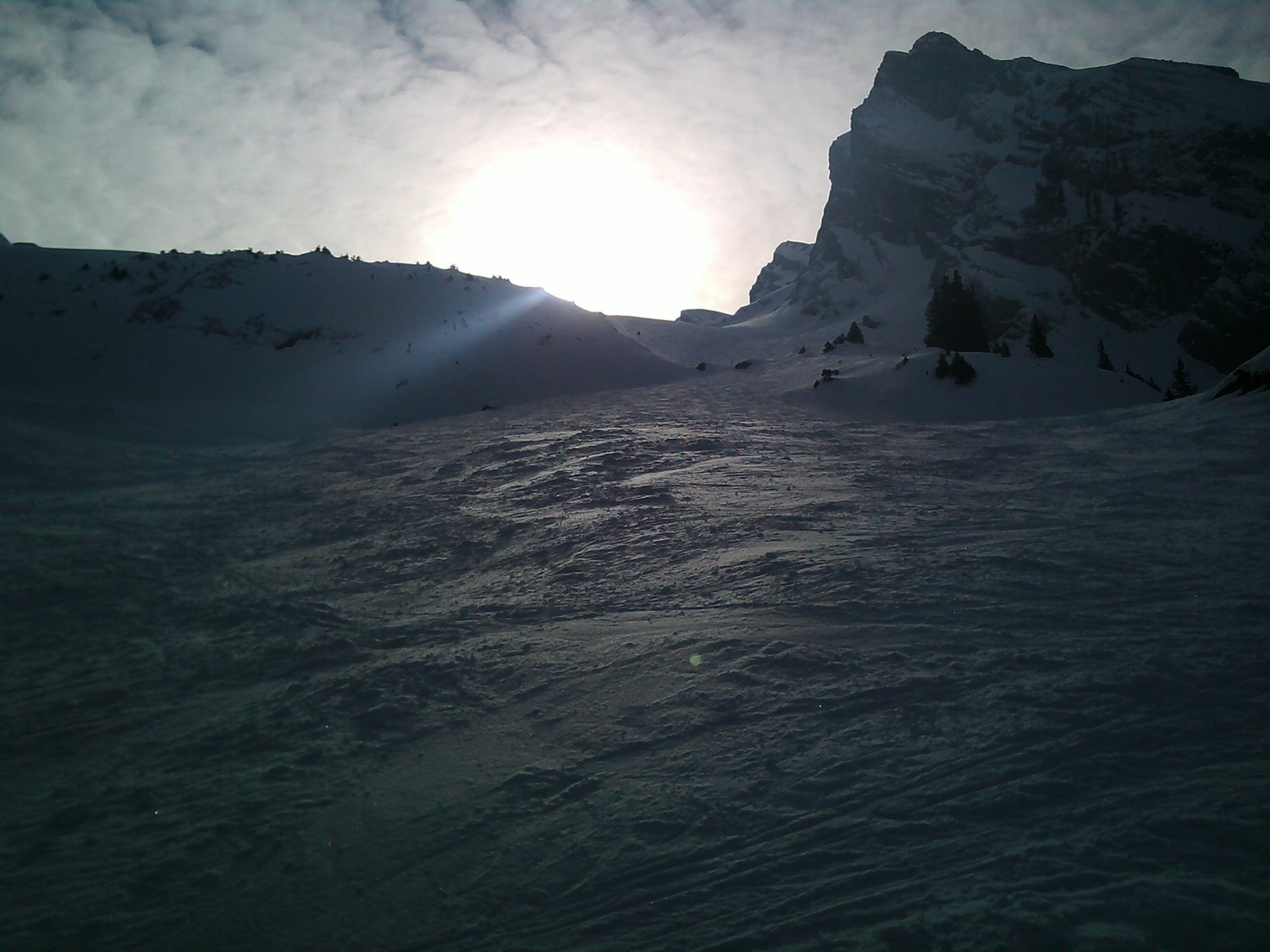 soleil voilé sur piste damée en bas de la Combe