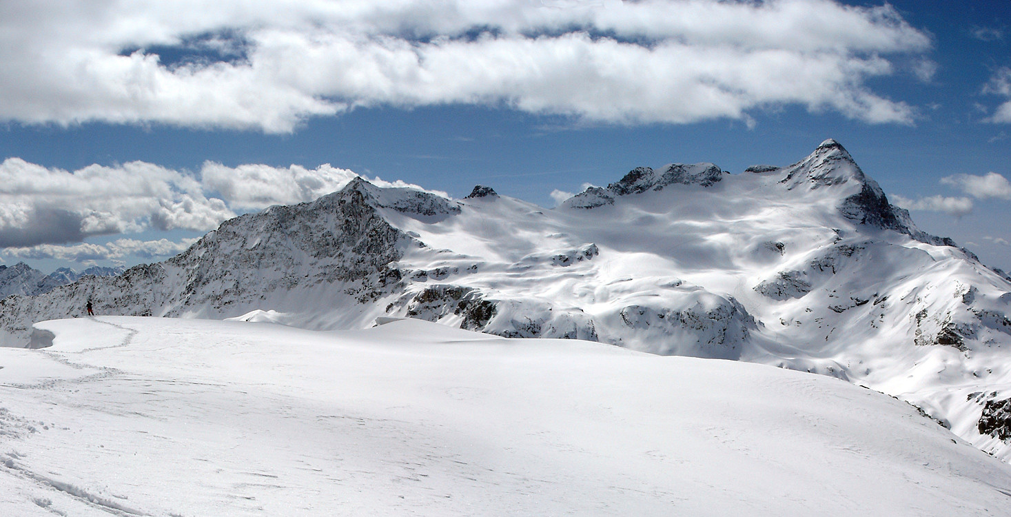 la vasta sommità del Corno Campascio. Sullo sfondo la triade Piz Cancian-Cima Val Fontana-Pizzo Scalino.