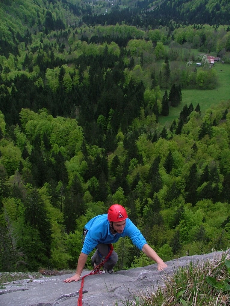 Sylvain arrive au sommet de la 2° longueur du "Vieux clou", en bas la clairière du Latay, au fond les Fontaines près de Samoëns