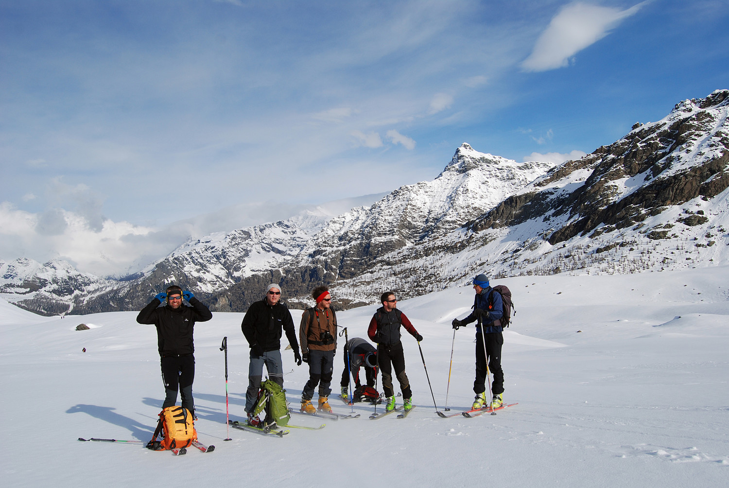 Sosta per vestirsi a causa delle raffiche di vento, con il Sasso Moro 3108 m sullo sfondo.