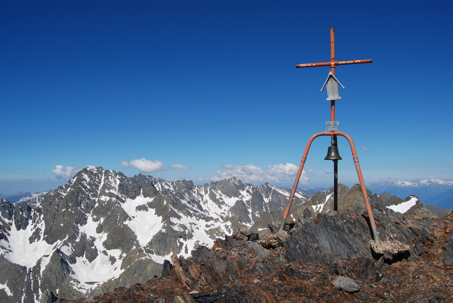 La caratteristica croce con campana al Pizzo del Diavolo di Malgina e con il Pizzo Coca 3052 m versante E.