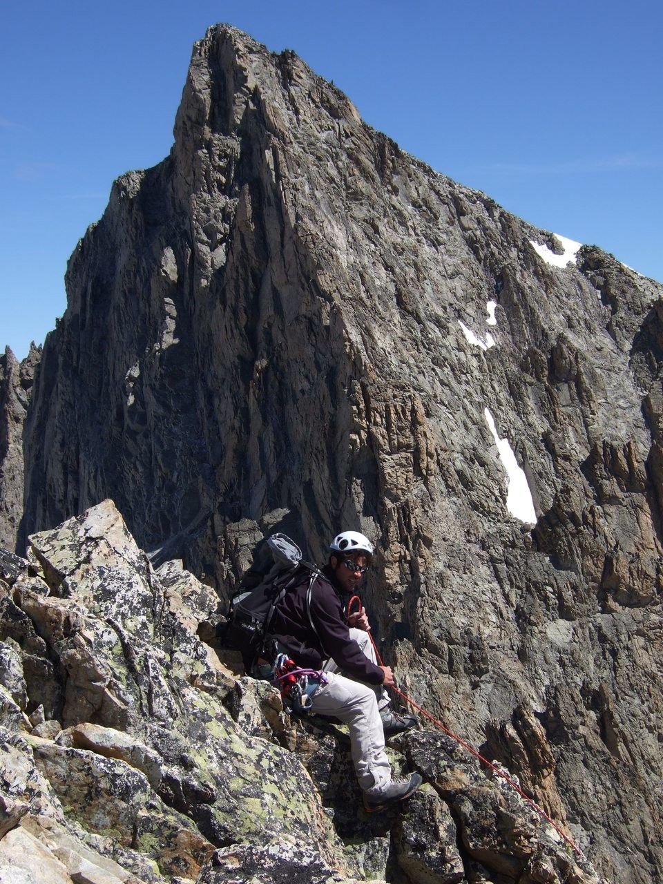 Lazare arrive au sommet sur fond de l'arête S de la pointe Brevoort