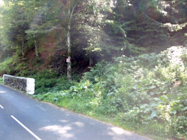 Le départ du chemin à droite pas évident si la végétation est dense. Escalade écrit sur le goudron.