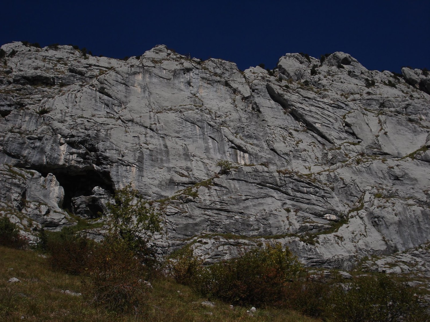 sous la grotte. La voie démarre en-dessous à droite