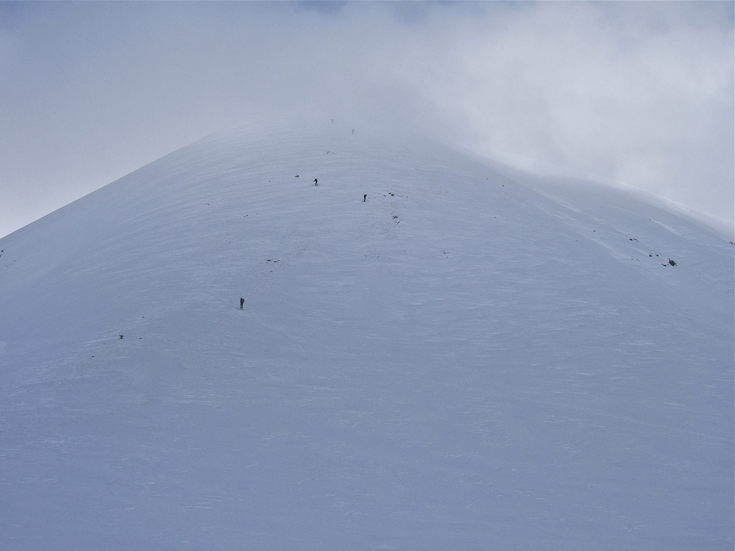 Crête manquant de neige sur le bas.Le sommet est accroché.