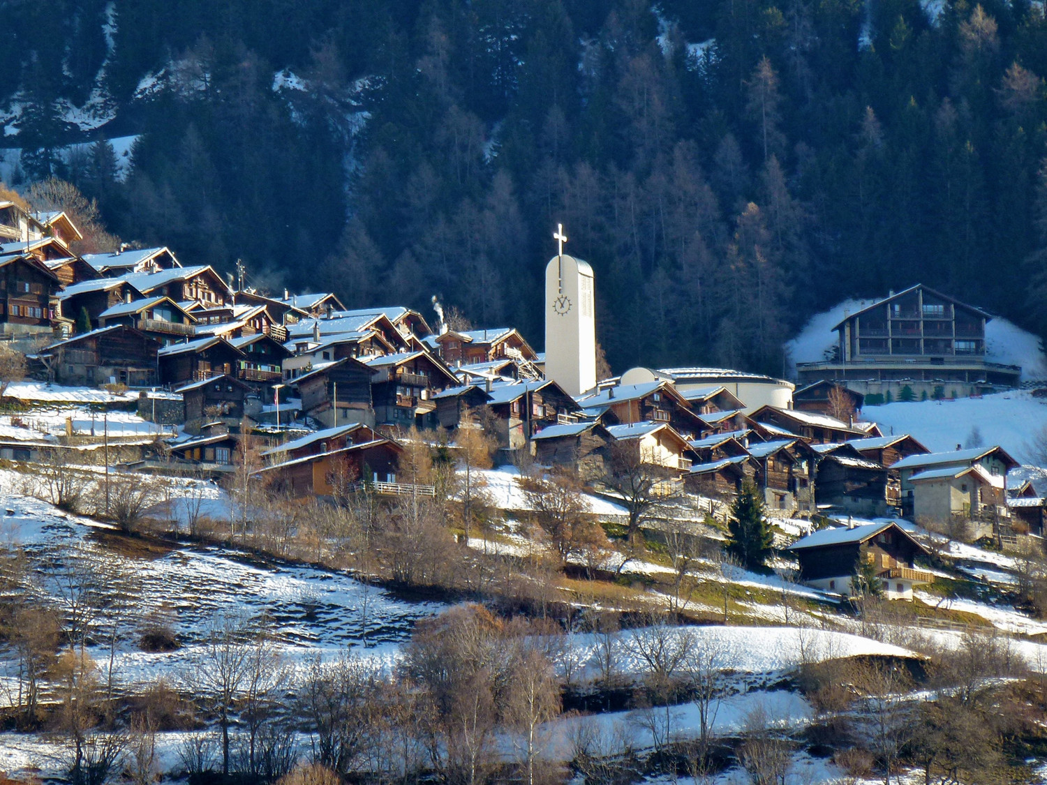 Superbe village aggripé à la pente.