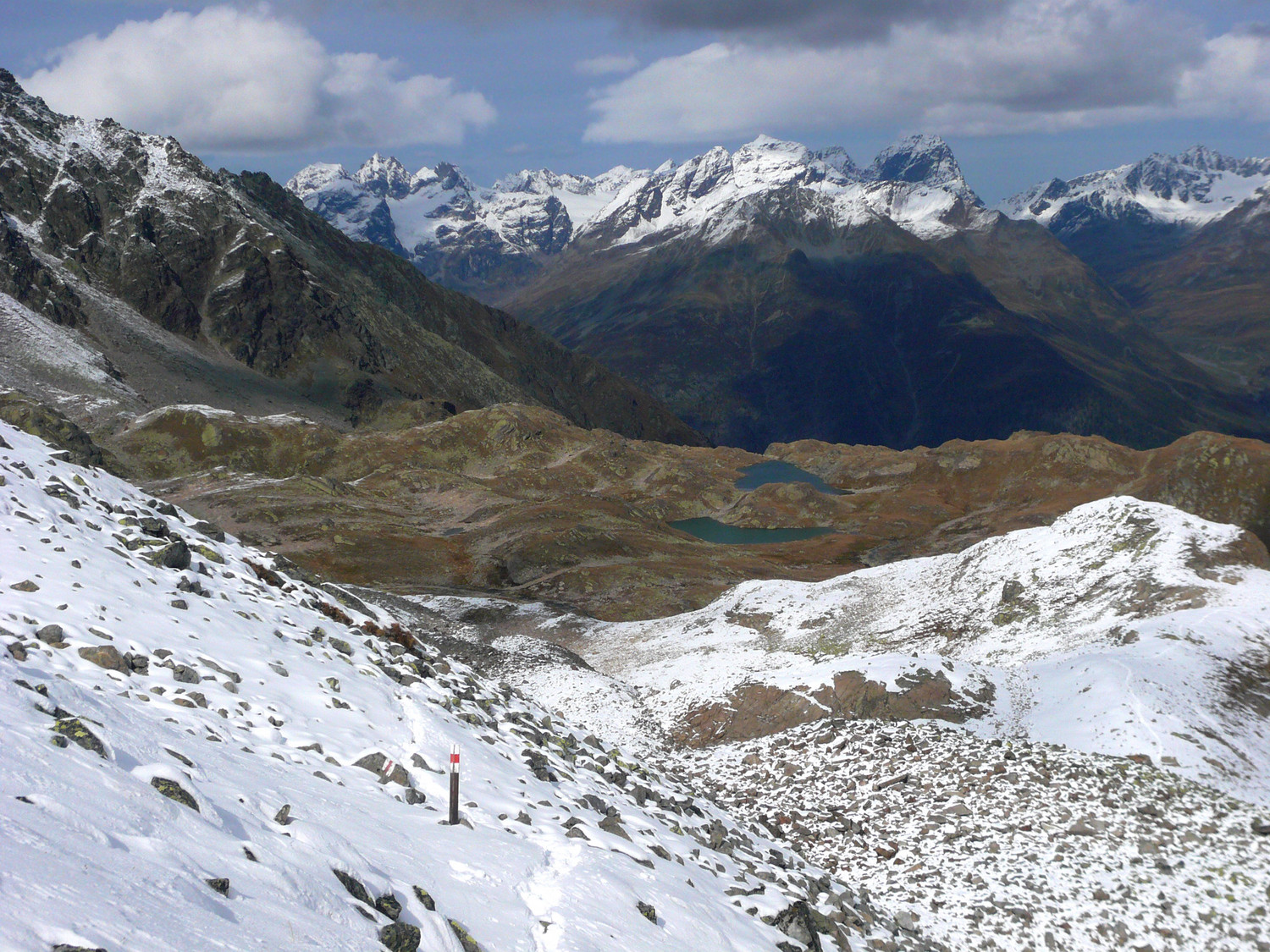 Sous le sommet du Munt Baselgia, la palette des lacs est bien visible en contrebas. Au fond, le massif de la Silvretta