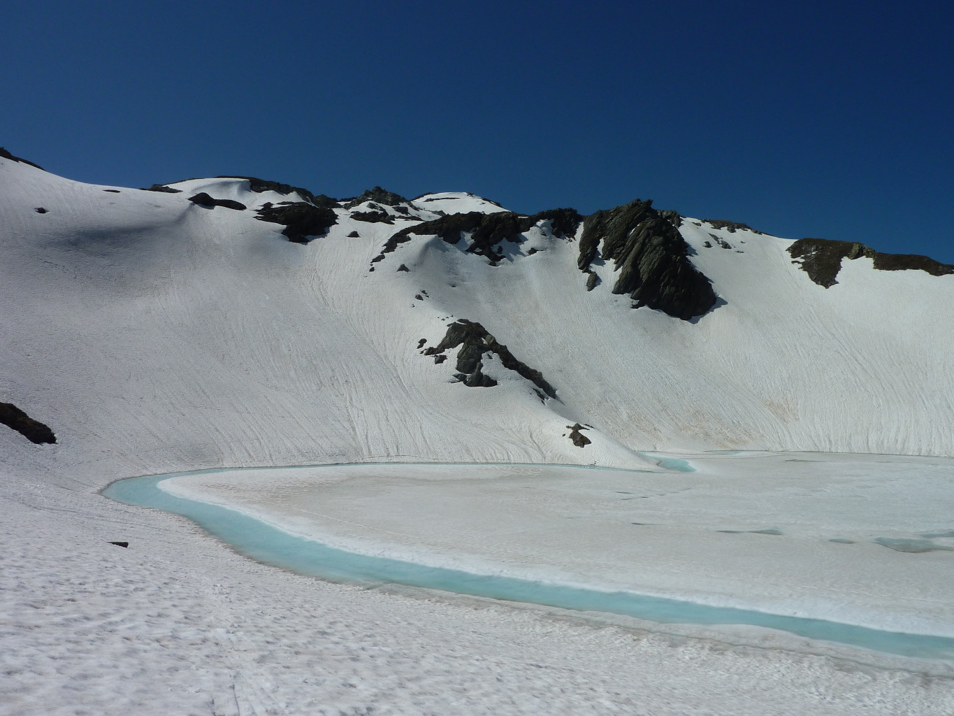 Lac de Fenêtre avec la pente skiée qui descend sur le lac.