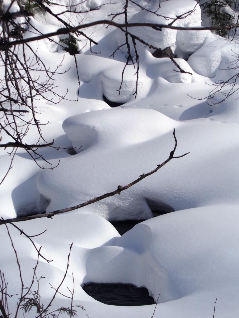 L'eau coule entre cailloux et neige
