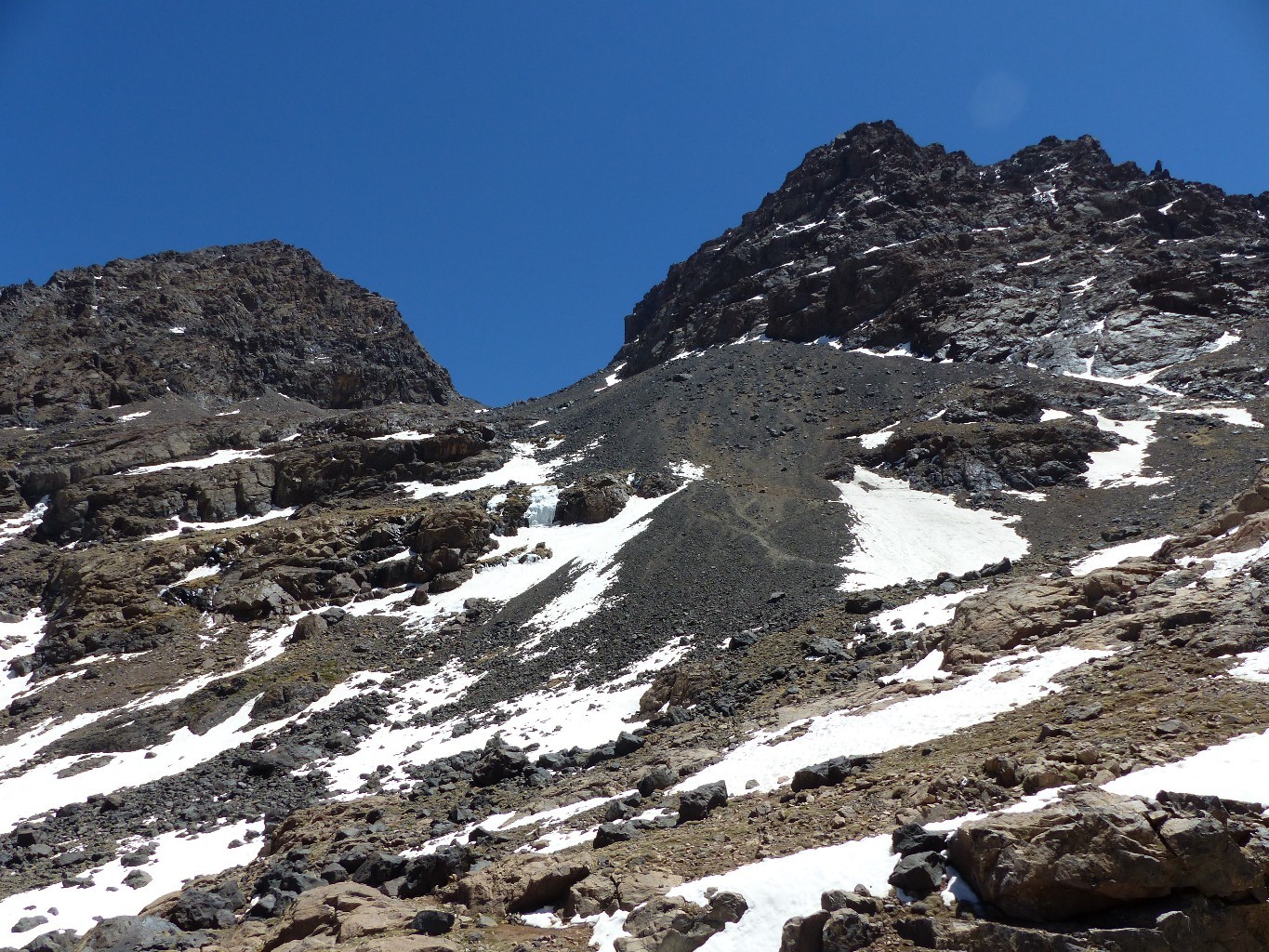 On passe bien au dessus de la cascade de glace, et on rejoint le pied de la barre rocheuse qu'on va longer jusqu'à trouver une sente jusqu'au faux co