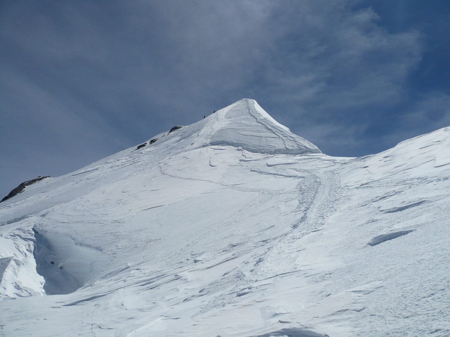 le sommet atteint par la bande blanche à gauche de l'arête