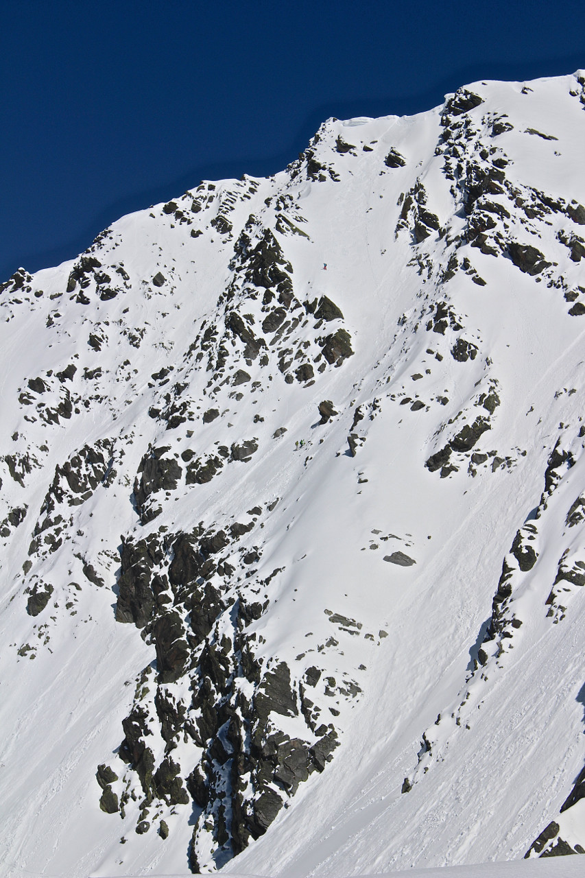 Trois petits points, des skieurs de pente raide dans le couloir central