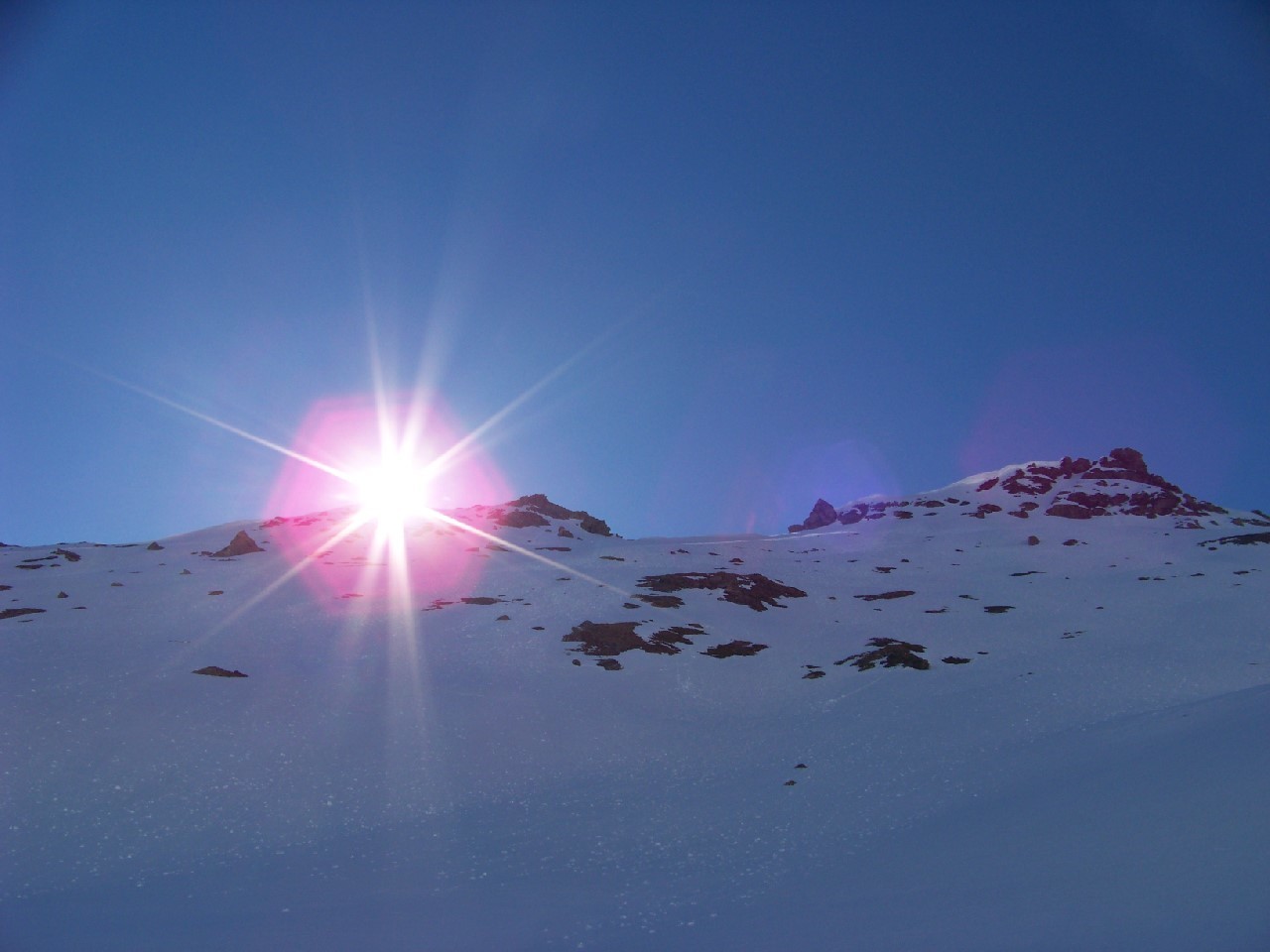 Le soleil sort derrière la cime du Laro.