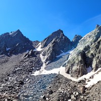 En montant au pas de Vens. Le pas de la Lauze est en haut à gauche des névés, et le bivouac Vigna juste à sa gauche